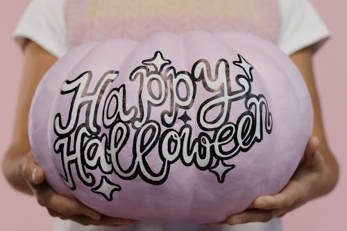 A Woman Holding a Painted Pumpkin