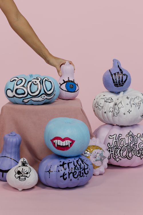 Free Halloween-themed pumpkins with creative designs on a pink background, perfect for festive decorations. Stock Photo