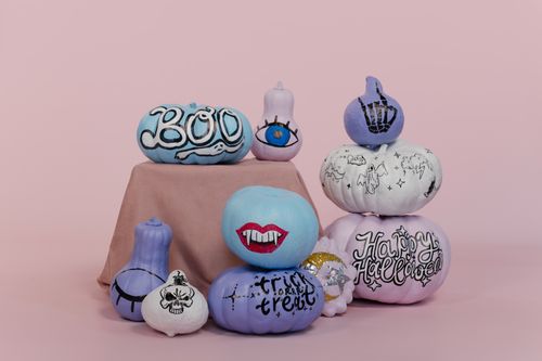Free Stacked, colorfully painted pumpkins themed for Halloween against a pink background. Stock Photo
