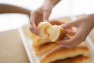 Person Holding a Bread With White Cream