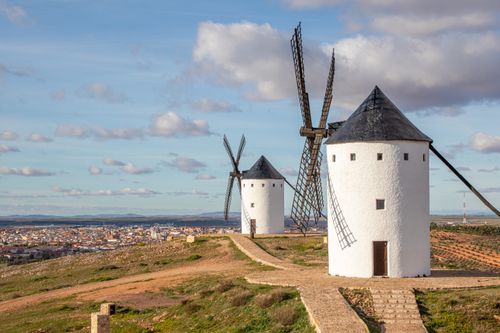 Free Scenic view of traditional windmills in Alcázar de San Juan, Spain, under a blue summer sky. Stock Photo