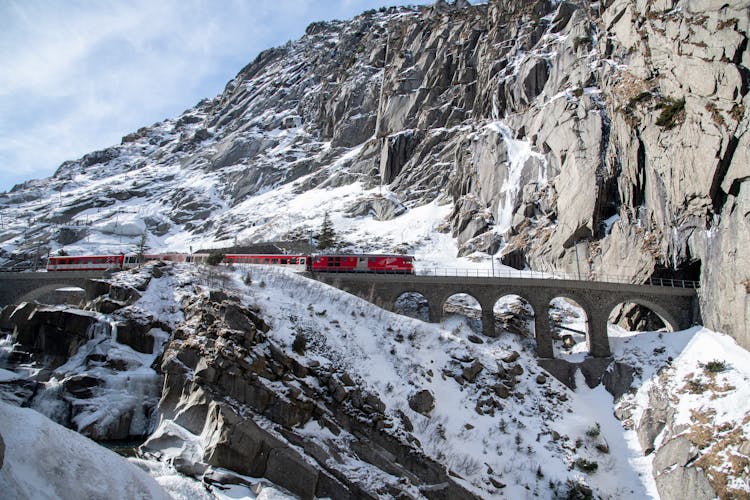 Train On Bridge To Tunnel In Mountains