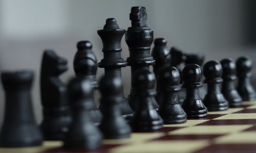 Free A detailed close-up of black chess pieces arranged on a chessboard, showcasing strategy and focus. Stock Photo