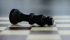 Black Chess Piece on Brown Wooden Chess Board
