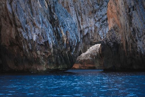 Free Picturesque scenery of rough rocky formation in calm ocean water with rippling surface Stock Photo
