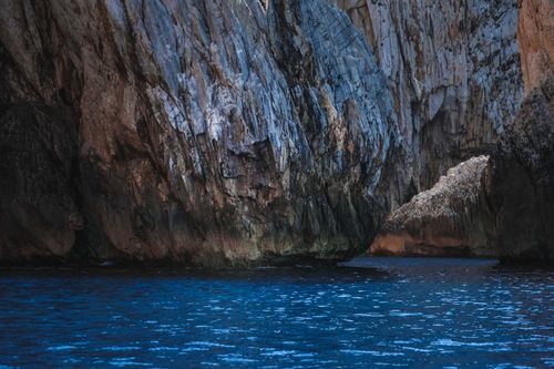 Free Scenic landscape of rocky formation with rough surface in calm turquoise sea water Stock Photo