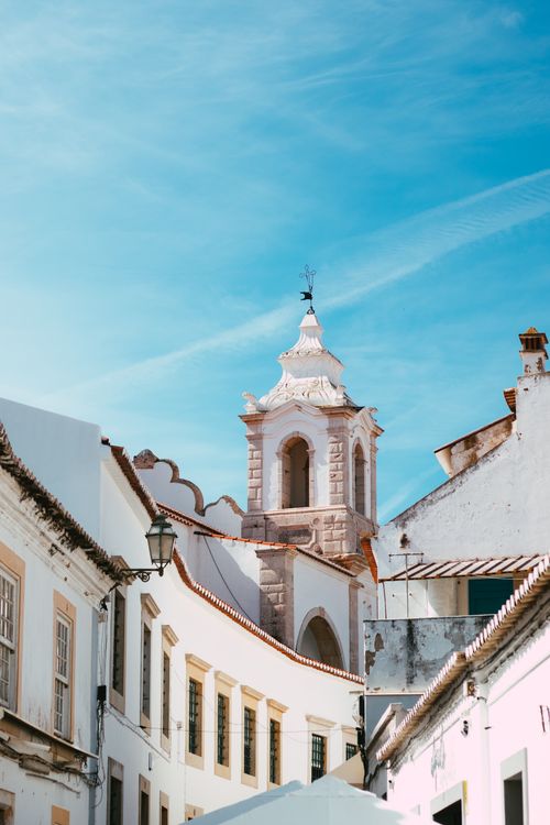 Free Picturesque church tower amidst old town whitewashed buildings in Lagos, Portugal. Stock Photo