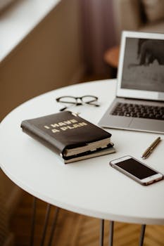 Sleek home office desk featuring a laptop, smartphone, and planner for organized remote work.