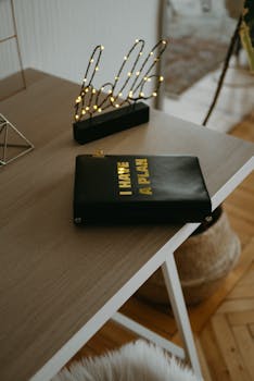 Cozy home office setup with a motivational planner and stylish lighting for productivity.