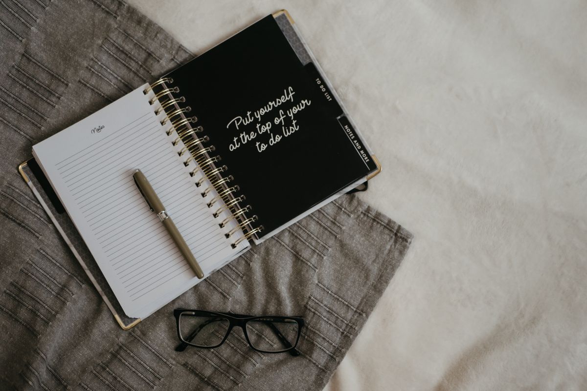 Person planning and writing recovery goals in notebook