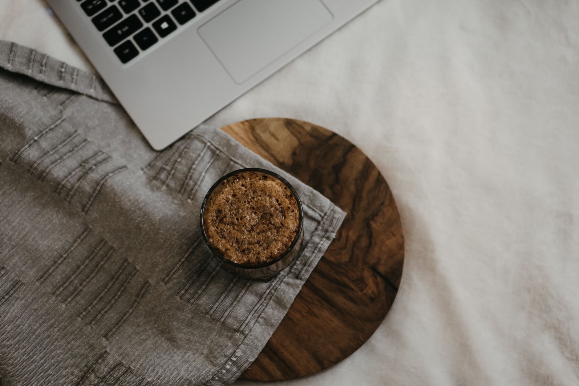A warm, cozy home office setup with coffee and laptop on a wooden surface, ideal for remote work.
