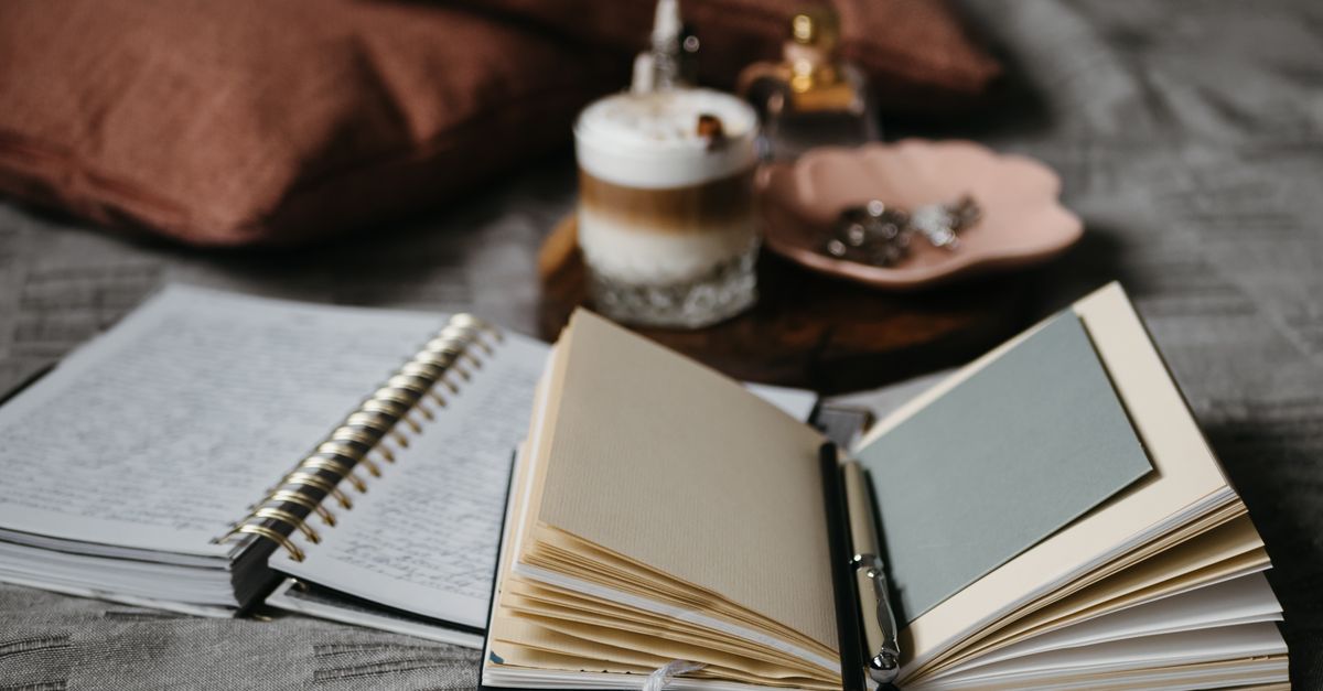 an open journal with a pen lying on it, soft natural light