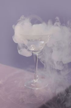 迷人的干冰烟雾缭绕着鸡尾酒杯，营造出迷人的氛围