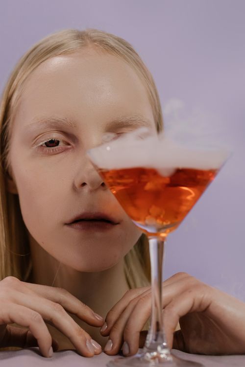 Free Eerie Halloween cocktail and vampire-inspired makeup for a mysterious celebration. Stock Photo