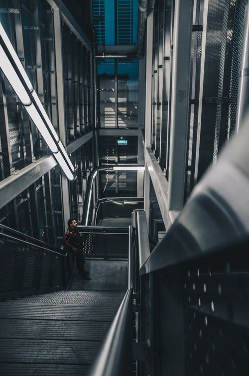 Free Dramatic photo of a man on a modern industrial staircase in Chicago at night. Stock Photo