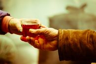 Person Holding Clear Drinking Glass With Brown Liquid