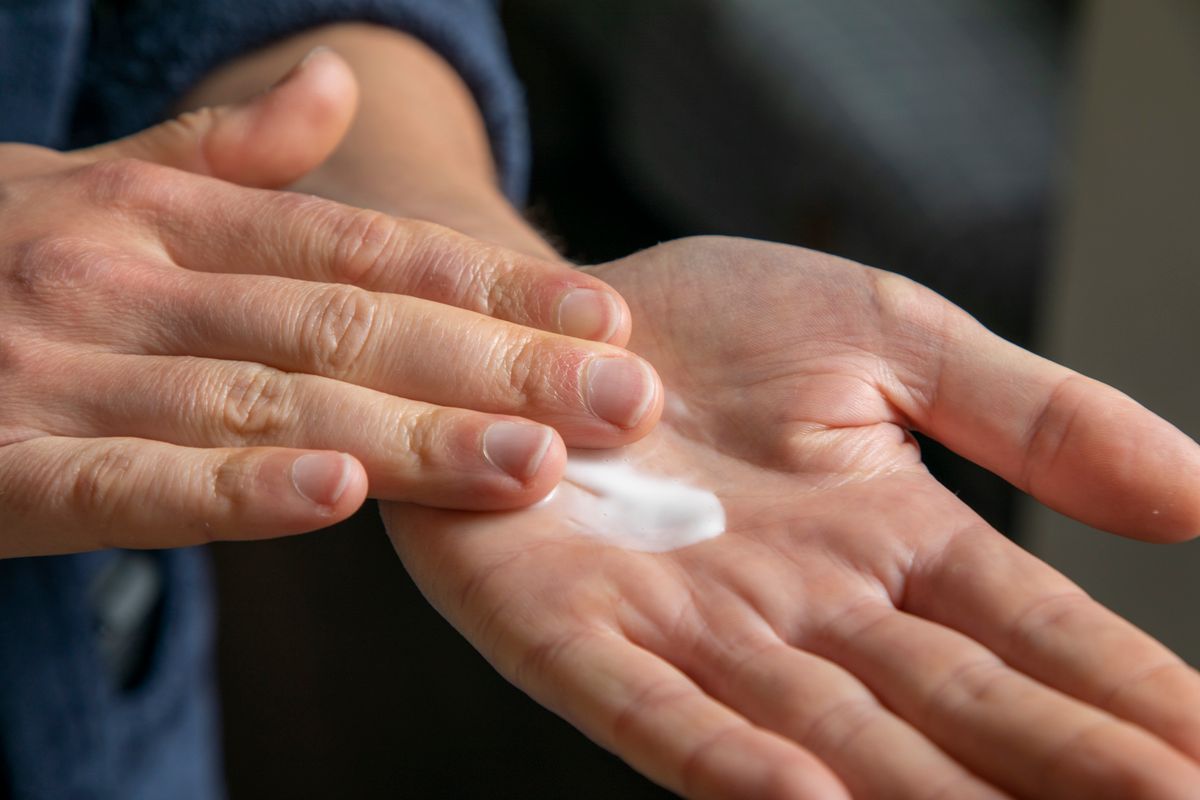 Close-up of cream being applied to the palm, similar to how cocoa butter is used on skin