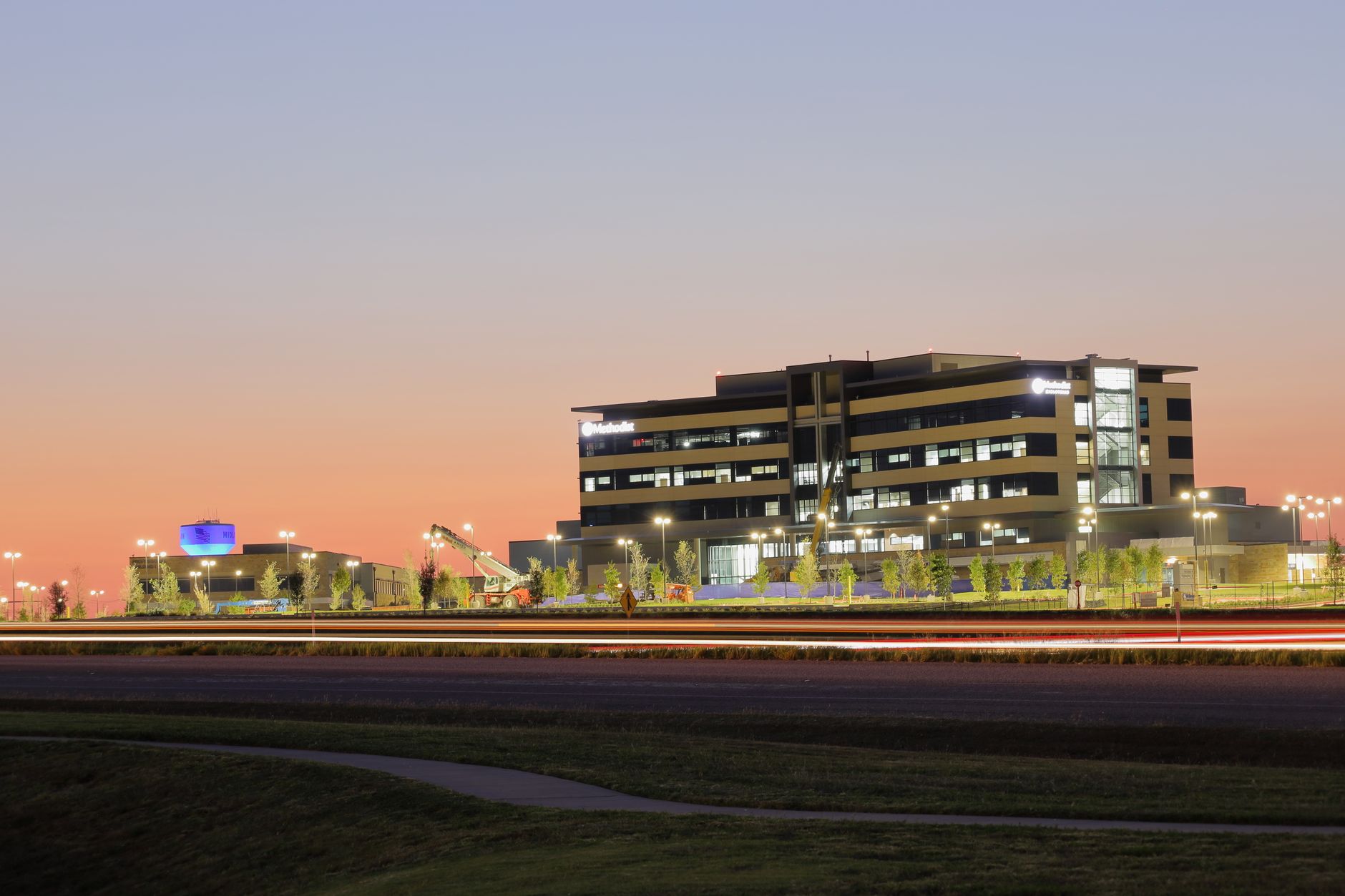 A modern building illuminated at sunset, featuring a sleek design and vibrant sky in Texas, USA.
