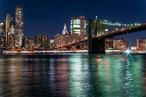 Illuminated New York City at Night with a View on the Brooklyn Bridge