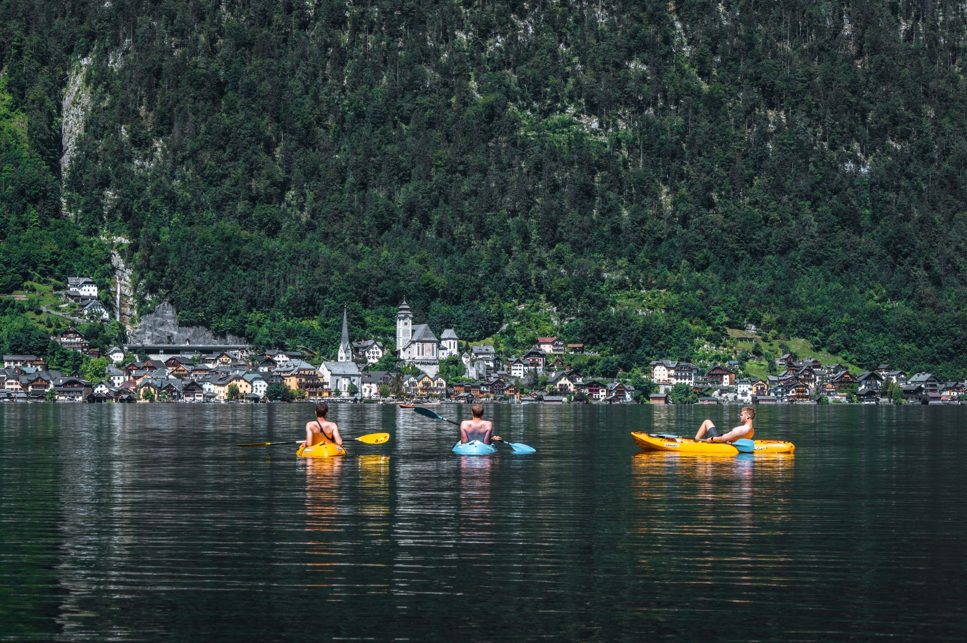 Paddlers enjoying kayaks on a calm mountain lake after safely transporting their boats
