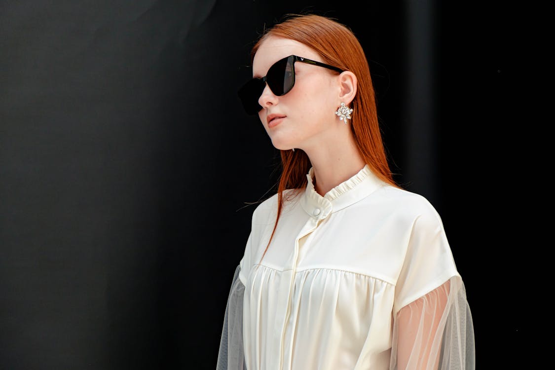 
A Woman Wearing Sunglasses and a White Top