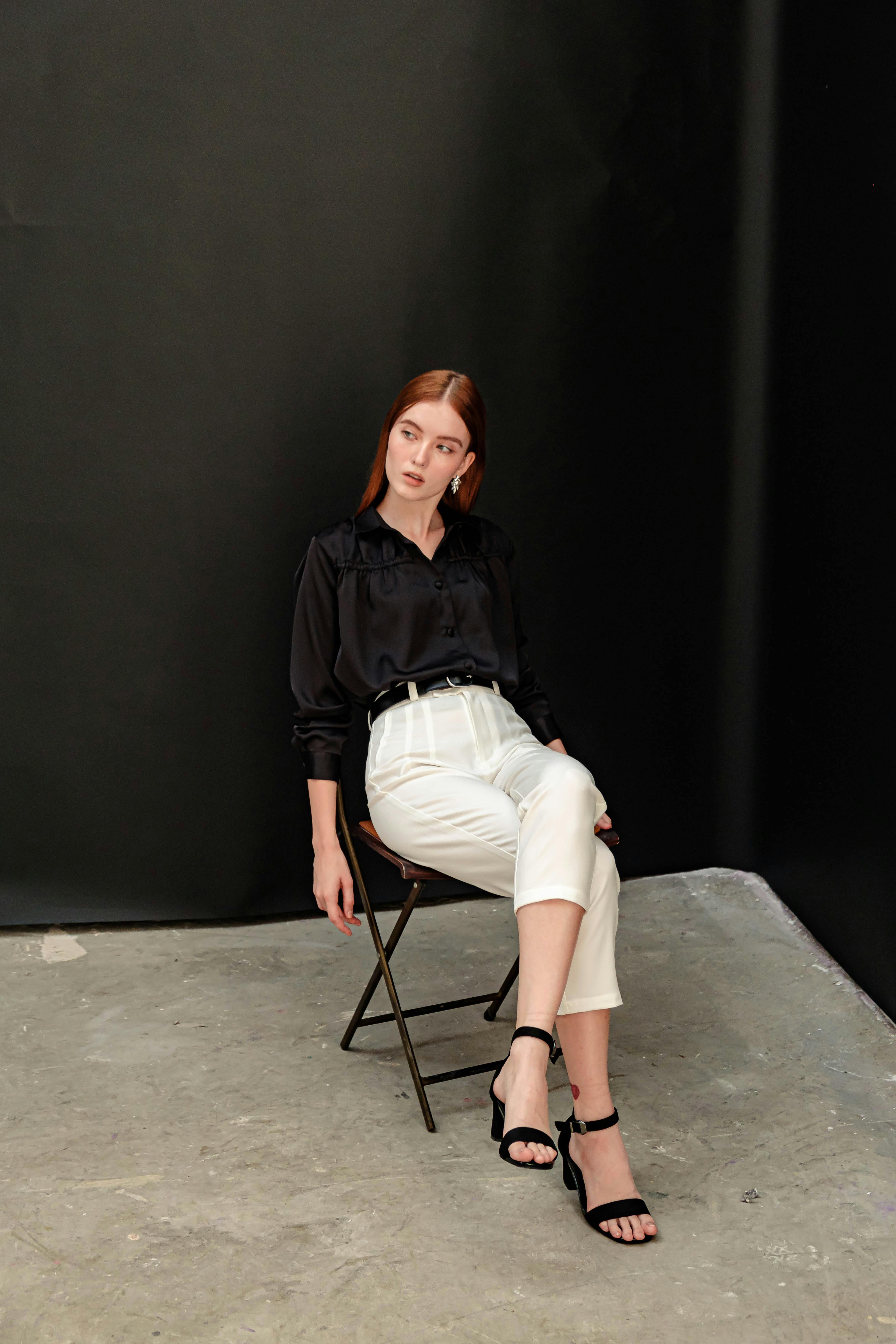 Elegant redhead woman posing in modern fashion against a dark backdrop. Perfect for fashion editorials.