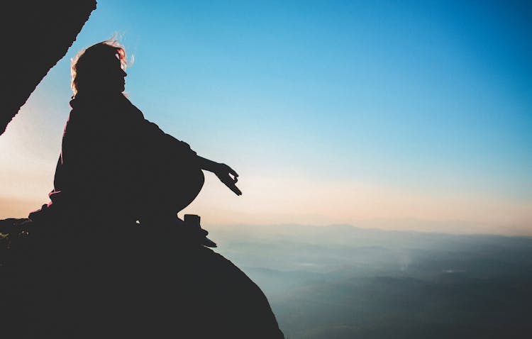 Silhouette Of Man Meditating In A Mountain Valley