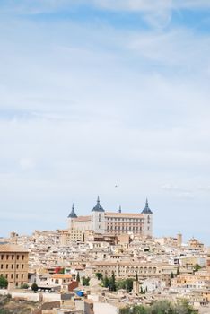 Stunning cityscape of Toledo, Spain featuring the iconic Alcázar castle under a clear blue sky.