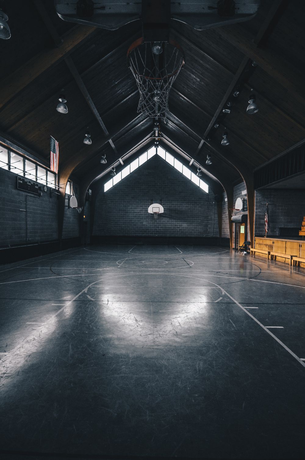 Dimly lit, empty basketball court with modern architecture