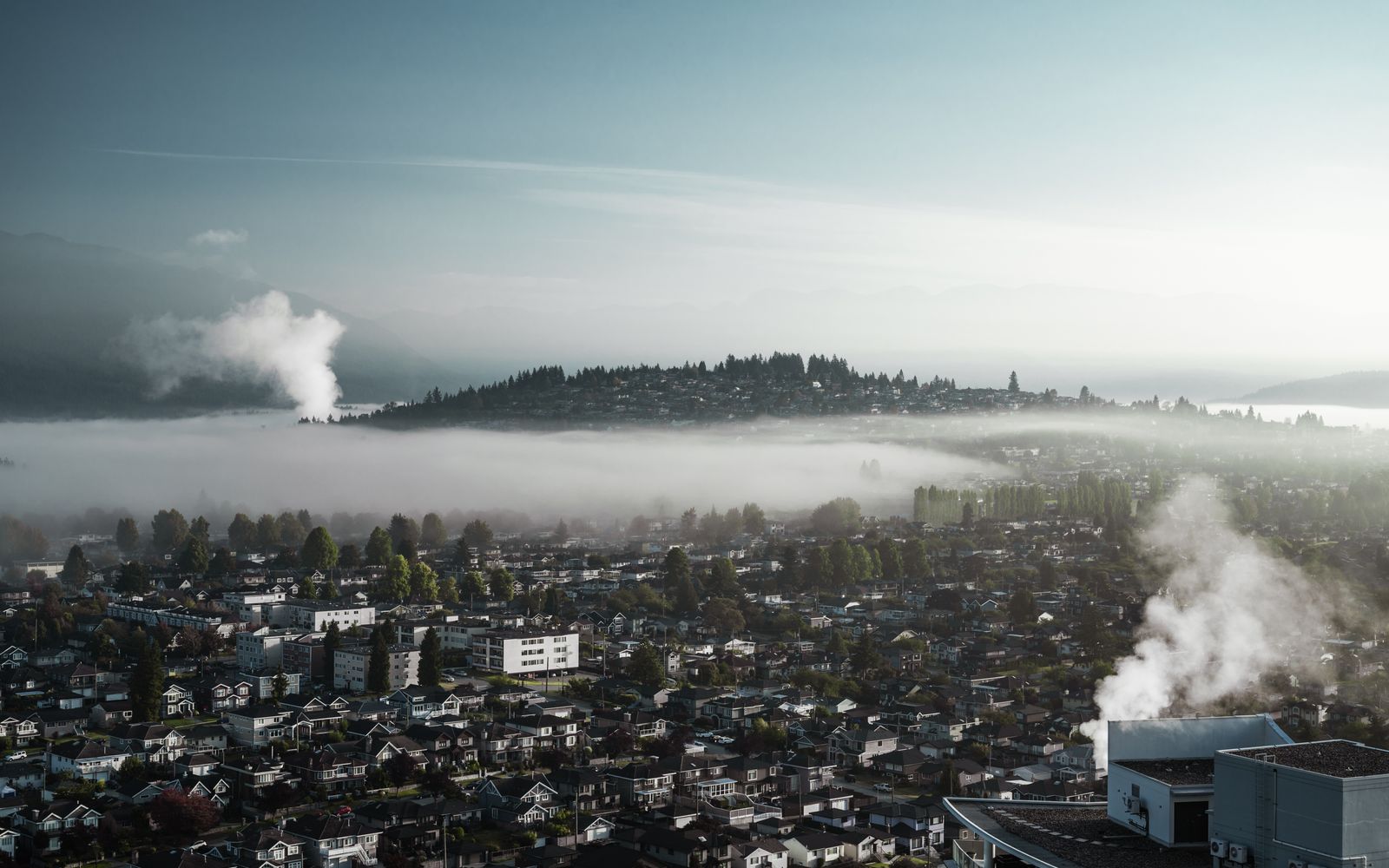 A city skyline enveloped in mist and smoke