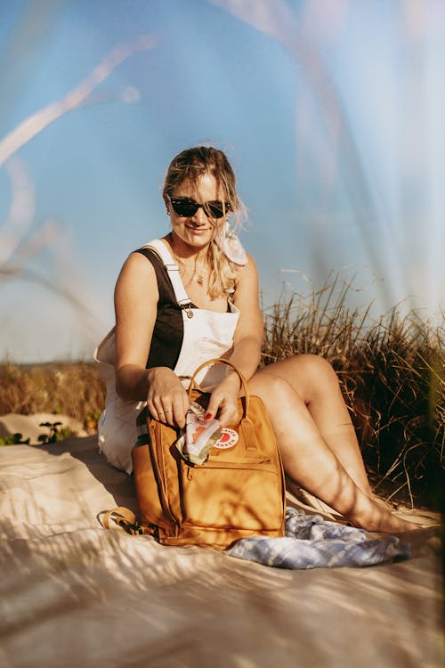 Cheerful woman sitting on sandy ground