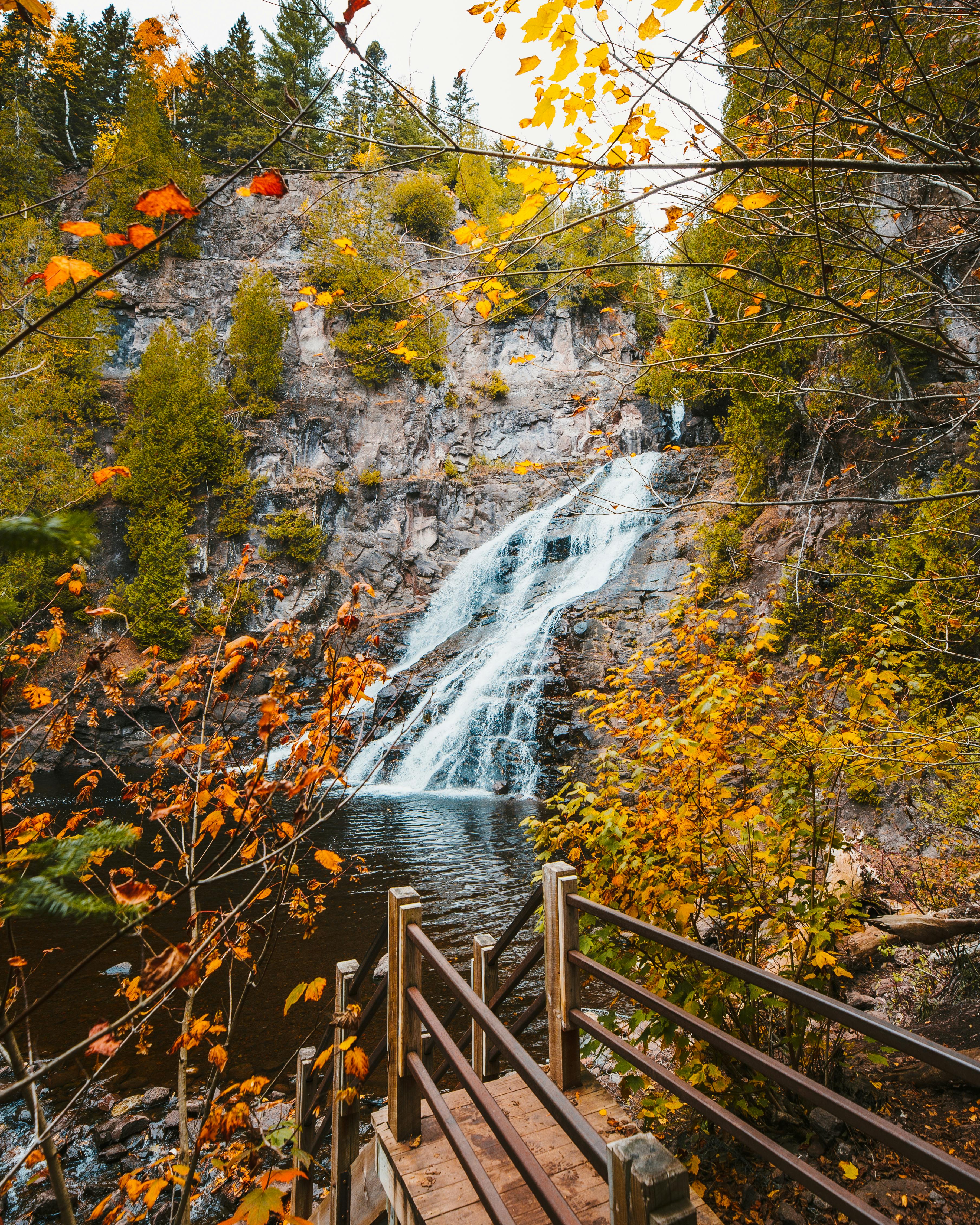 brown wooden bridge over water falls