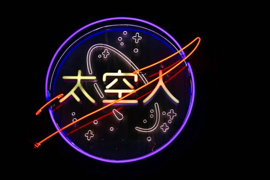 霓虹灯招牌色彩缤纷，以太空主题为特色，并在深色背景上印有中国字