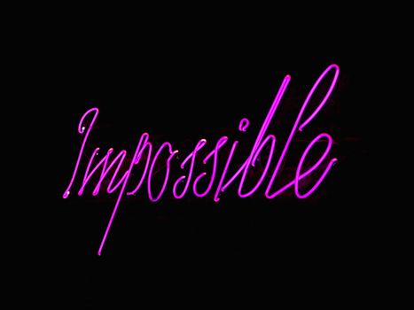 Eye-catching neon 'Impossible' sign glowing against a dark backdrop, perfect for inspirational themes.
