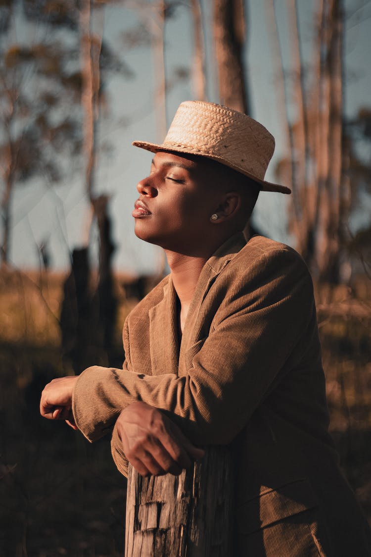 Stylish Black Man Leaning On Wooden Post