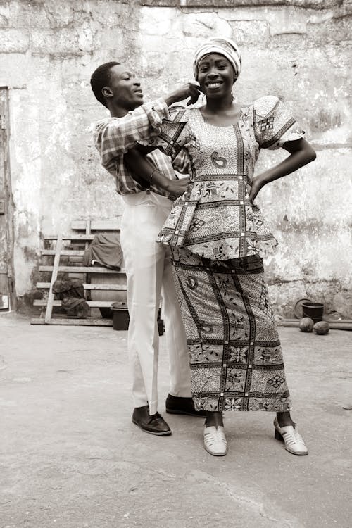 Man Fixing The Turban of a Woman in Printed Dress 