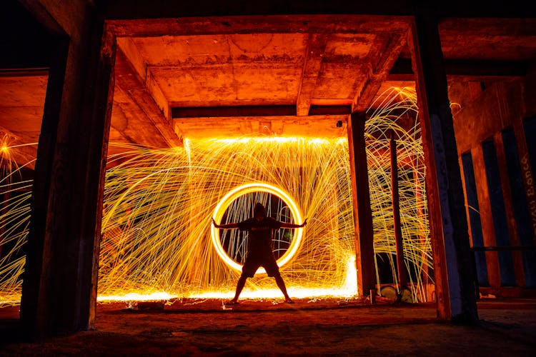 Silhouette Of A Man Standing In Front Of The Illuminated Circle