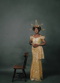 非洲妇女身着精致的传统服装，在古董椅子旁摆姿势