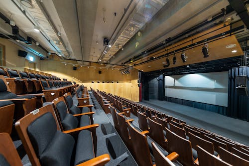 Empty Auditorium with Rows of Seats and Lecture Screen