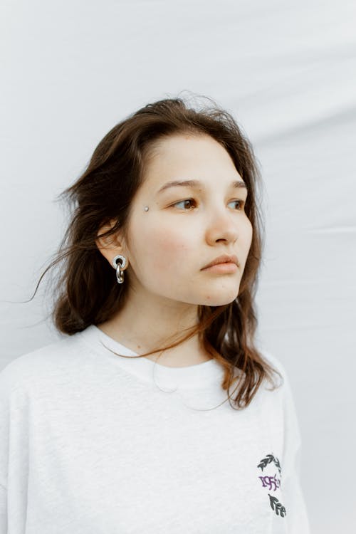 Pensive Woman in White Crew Neck Shirt Looking Afar