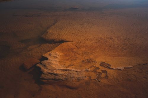 Free High agle of rippling sea surface and sandy floor with rocky rough formations Stock Photo