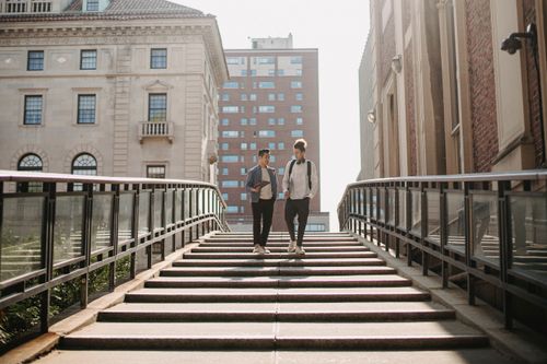Free Full length of students in casual clothes walking downstairs and talking in residential district in city in daytime Stock Photo