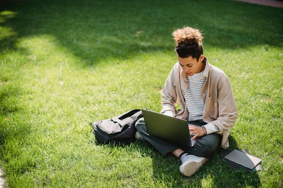 Serious student typing on laptop keyboard during studies