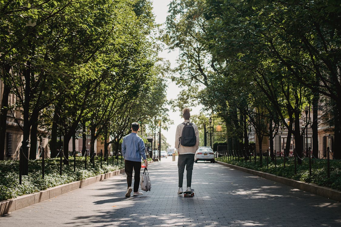 Male skateboarder riding near friend in park