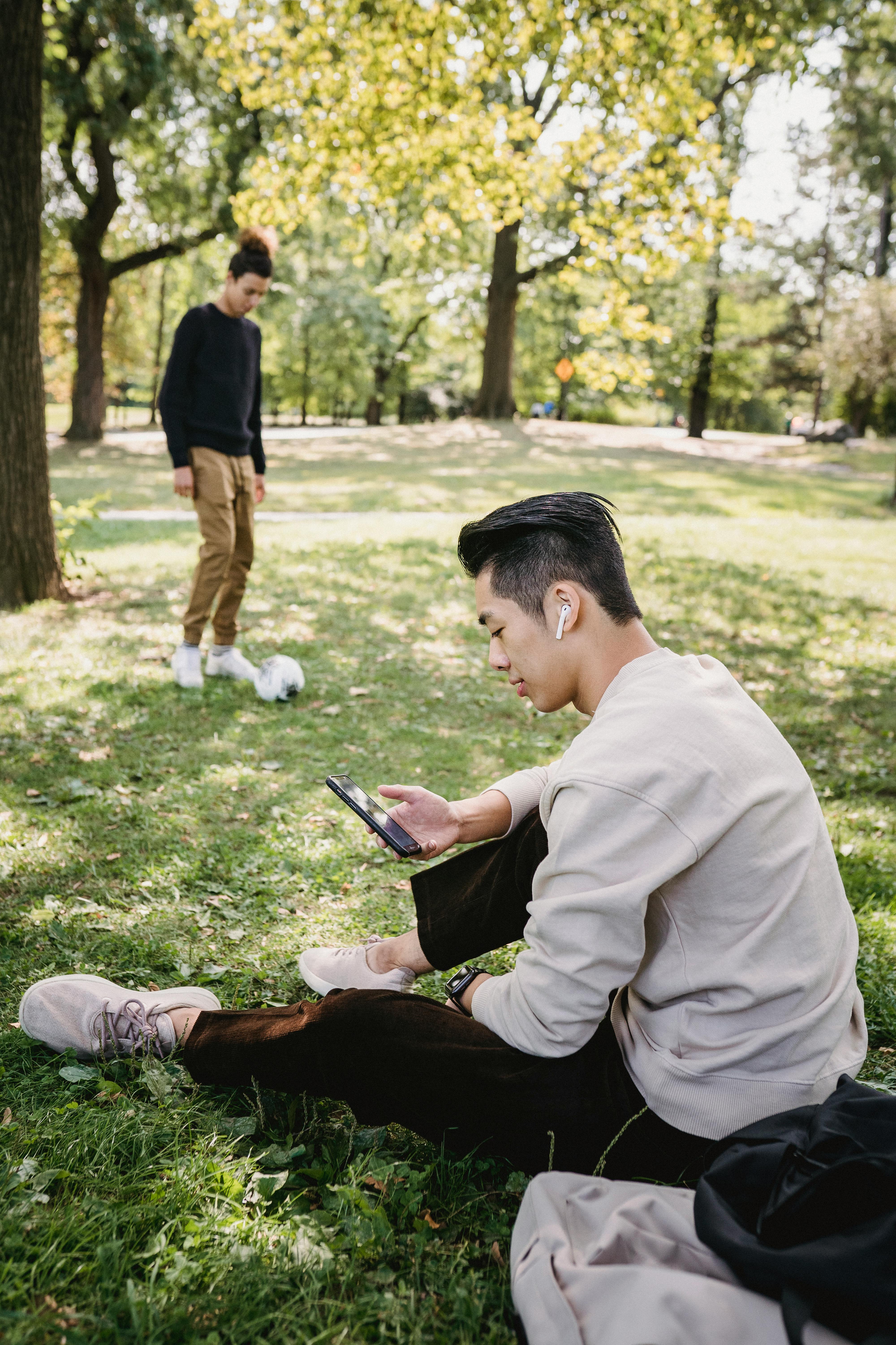 ethnic man browsing smartphone in park