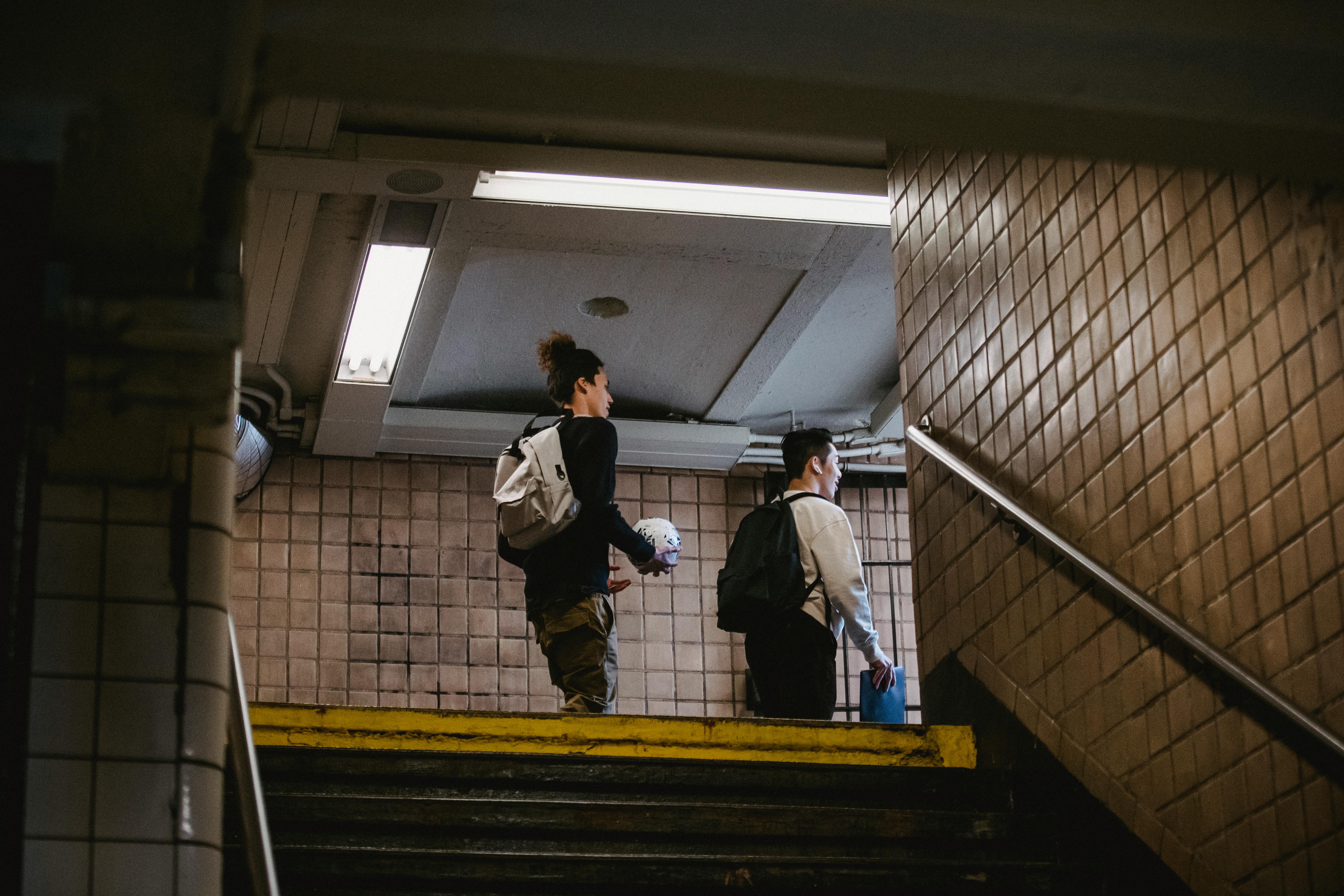young men walking on metro staircase