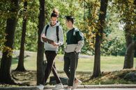 阳光明媚的公园里，两名大学生一边散步一边讨论学术话题