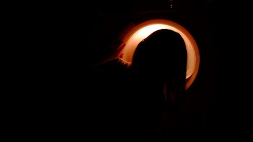Low Light Photography of Girl Looking at Washing Machine