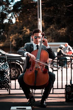 Talented cellist in sunglasses performing on a city street with captivating style.