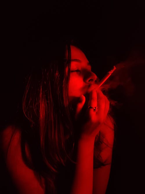 Free Woman in Black Tank Top Smoking Cigarette Stock Photo